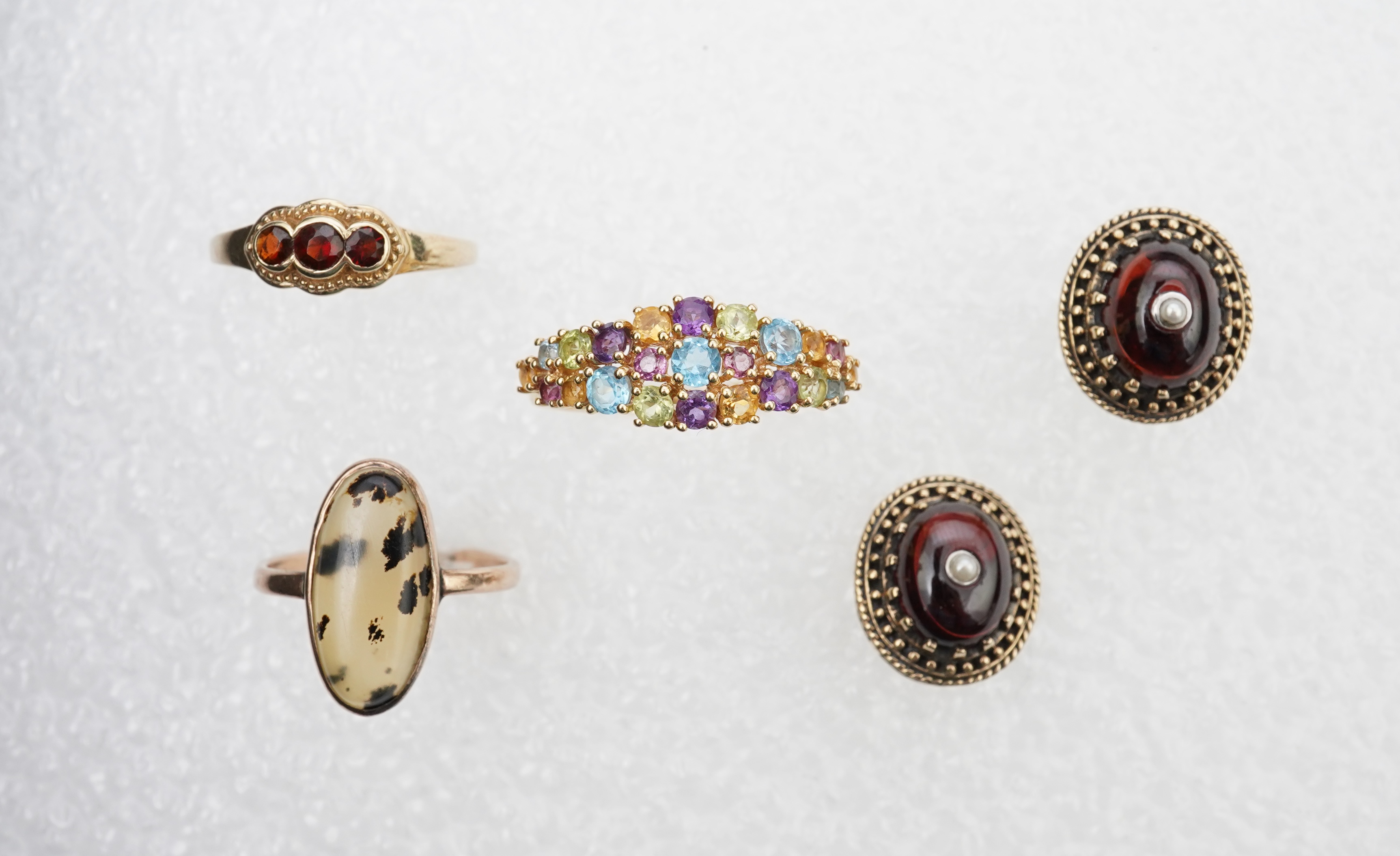 A modern 18ct gold and multi gem set cluster ring, size P, together with two 9ct rings including moss agate and a pair of 9ct gold and seed pearl set cabochon garnet ear studs.